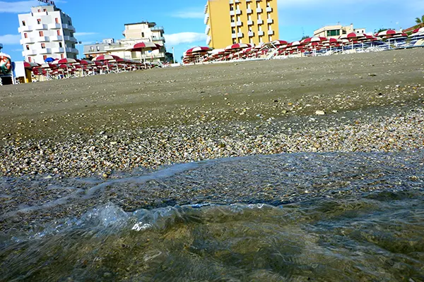 Primo piano delle onde che bagnano la spiaggia