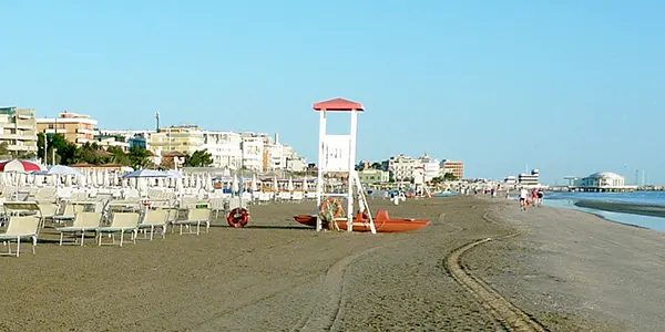 Torretta del bagnino sulla piaggia con moscone rosso del salvataggio