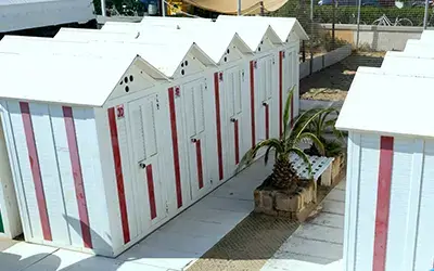 Cinque cabine bianche sulla spiaggia