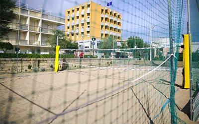 Campo da beach volley visto da dietro la rete di protezione