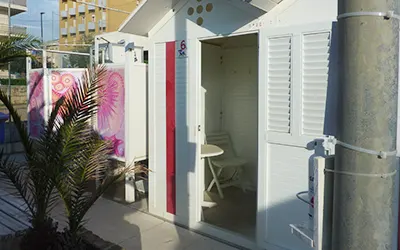 Cabina spogliatoio con la porta aperta e dentro sedia e tavolino